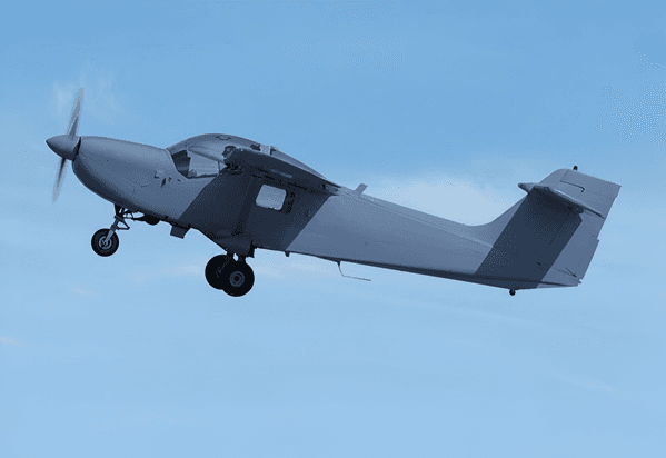 Aviation parts warehouse with avionics instruments, engine components, and a light aircraft in the hangar